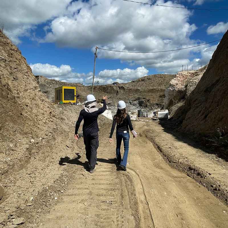 Engenheiro de minas e geóloga entrando na área de operação de uma pedreira.